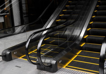 Empty escalators stairway with a yellow stripes.