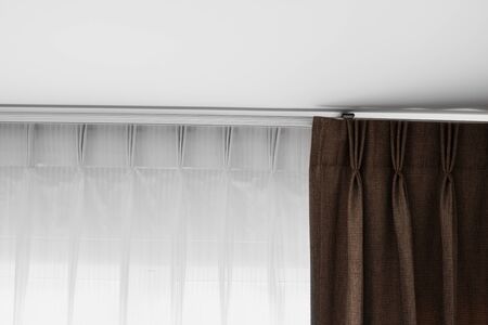 Brown curtains and white tulle on a rail with a white ceiling. Curtain interior decoration in living or sleeping room. Comfortable live in your own home. Sweet confy homeの写真素材