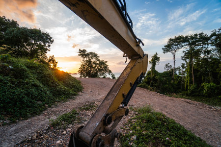 Details of modern excavator on the construction site with sunset sky. Large tracked excavator...