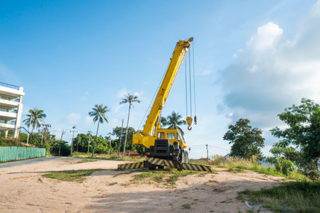 Yellow automobile crane with risen telescopic boom outdoors. Mobile construction crane on a...