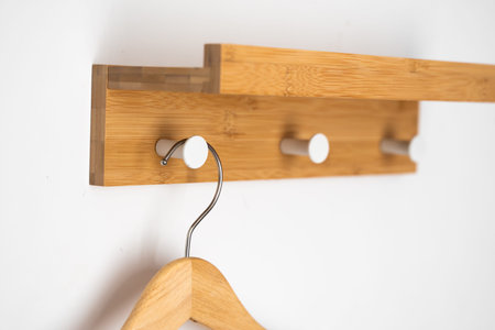 Clothes wooden hanger on a white wall.
