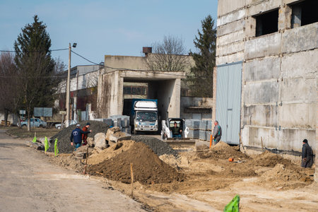 UKRAINE, LUTSK - April 1, 2020: White skid steer loader at a construction site working with a soil....