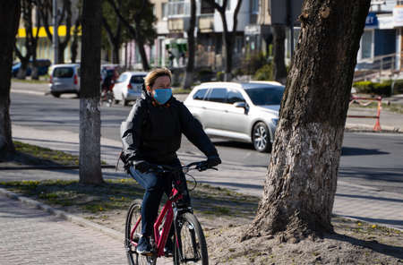 UKRAINE, KYIV - April 20, 2020: Man wearing a medical mask to prevent germs, toxic fumes, dust. Prevention of bacterial infection Corona virus or Covid 19 epidemic on street. Coronavirus global pandemic quarantine.のeditorial素材