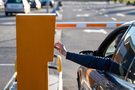 Person in the car inserting into or removing ticket from parking vending machine. Paying, entering...