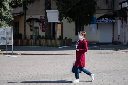 UKRAINE, KYIV - April 25, 2020: Woman wearing a medical mask to prevent of bacterial infection...