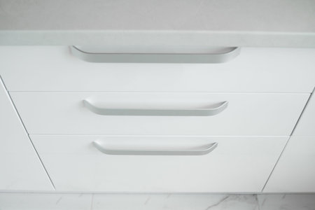 White lacquered kitchen facades on a comfortable kitchen. Modern white kitchen clean interior design