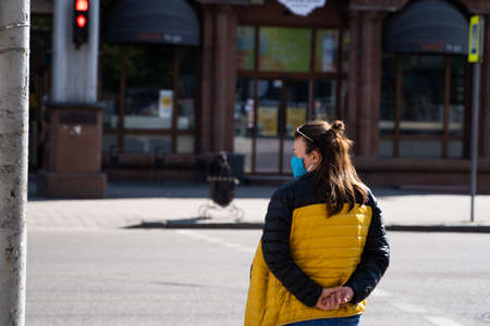 UKRAINE, KYIV - April 25, 2020: Woman wearing a medical mask to prevent of bacterial infection Corona virus or Covid 19 epidemic on street.のeditorial素材