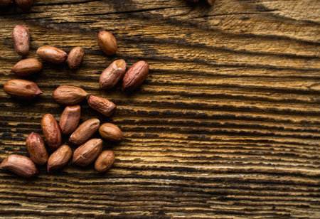 Peanut nuts scattered on the wooden vintage table. Peanuts nut is a healthy vegetarian protein...