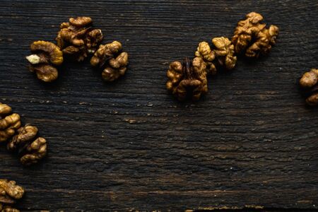 Walnut scattered on the wooden vintage table. Copy space. Walnuts is a healthy vegetarian protein nutritious food. Almonds on rustic old wood.の写真素材
