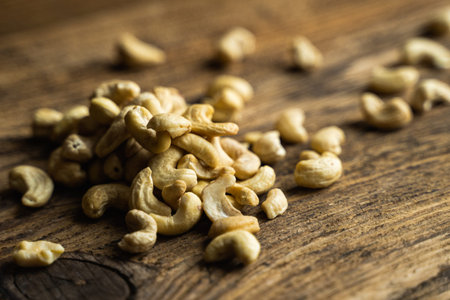 Cashew nuts scattered on the wooden vintage table. Cashew nut is a healthy vegetarian protein nutritious foodの写真素材