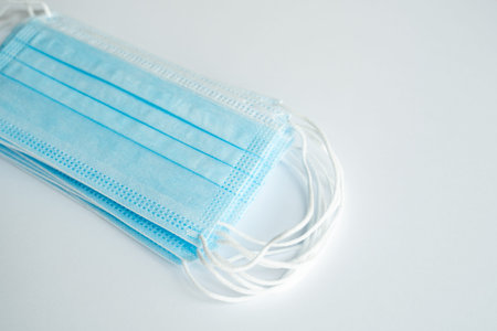 Medical protective masks on a gray background. Disposable 3-ply medical mask to cover the mouth and...
