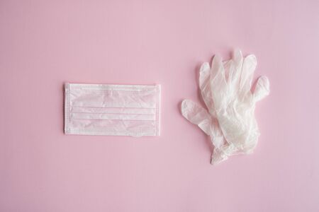 Medical protective mask and rubber gloves lie on a pink background. Anti-virus protection kit against covid-19. Coronavirus pandemic 2019.の写真素材