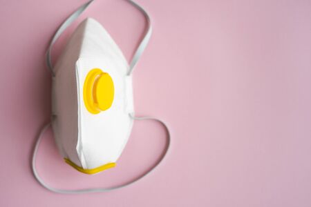 Respirator mask FFP or dust mask to cover the mouth and nose prevent coronavirus isolated on pink background. Breathing protection against air pollution, flu and coronavirus.の写真素材