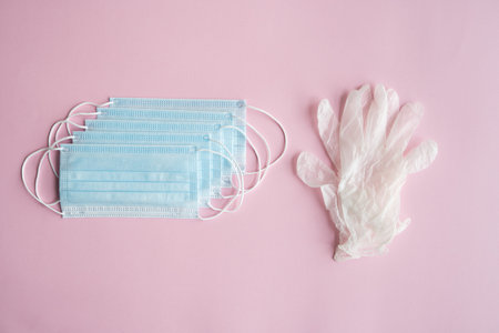 Medical protective mask and rubber gloves lie on a blue background. Anti-virus protection kit...