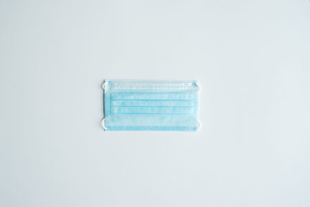 Face medical mask on a gray background. Disposable 3-ply medical mask to cover the mouth and nose to...