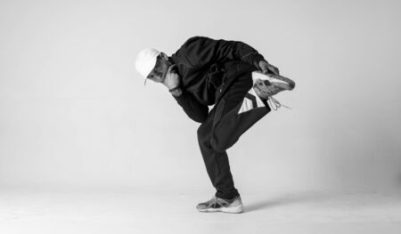 A man hip hop dancer or bboy freezes in one pose on a white background. Bboy doing stylish stunts.の写真素材