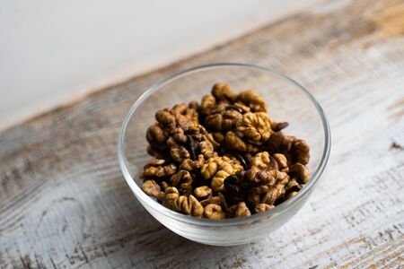 Walnut in a small plate on a vintage wooden table. Walnuts is a healthy vegetarian protein nutritious food. Natural nuts snacks.の写真素材