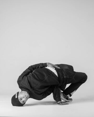 A man hip hop dancer or bboy freezes in one pose on a white background. Bboy doing stylish stunts.の写真素材