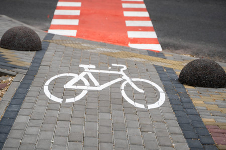 Cycling path with a symbol of bike on a ground through avtomobile road. Bike path in a modern city.