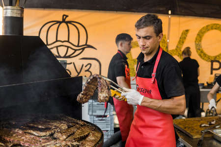UKRAINE, LUTSK - June 5, 2019: Man is cooking pork ribs on a grill on a food festのeditorial素材