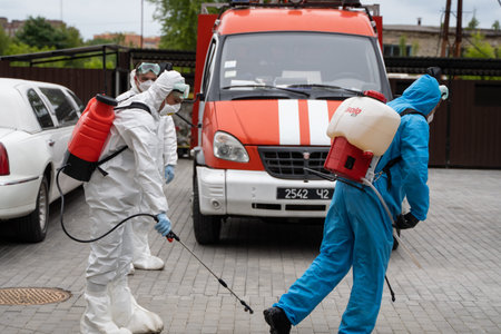 UKRAINE, KYIV - May 20, 2020: Man in a white protective suit and mask is standing near a car...