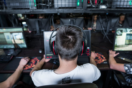POLAND, WARSAW - June 10, 2020: Back view of young gamer in headphone playing video game at computer...