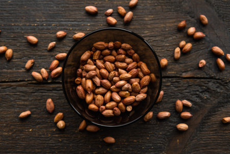 Peanut nuts in a small plate on a vintage wooden table. Peanuts nut is a healthy vegetarian protein...