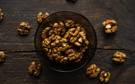 Walnut in a smale plate with scattered shelled nuts and whole nut which standing on a wooden vintage...