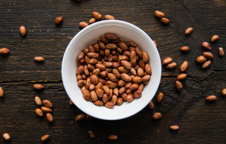 Peanut nuts in a small plate on a vintage wooden table. Peanuts nut is a healthy vegetarian protein...