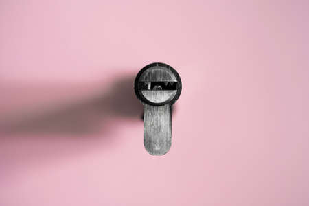 A door lock cylinder core on the pink background. The cylinder of the lock. Installing a new lock on the door. Spare parts for the door.の写真素材