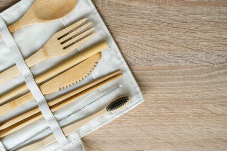 Eco friendly bamboo cutlery set in a case on a table. Zero waste concept. Set of bamboo cutlery in a case on a laying on a table. Spoon, fork, knife, toothbrush, tube and chinese sticks.の写真素材