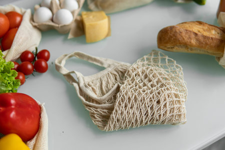 Eco friendly canvas grocery bag. Vegetables, fruits in reusable eco cotton bags and orange juice in...
