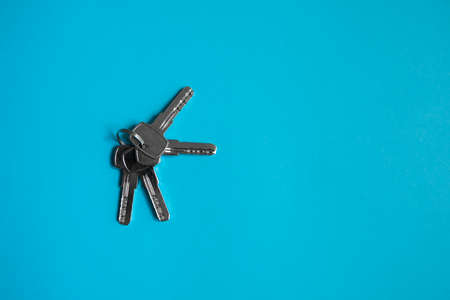 Door key lies on blue background. Set of keys. Bunch of keys. House key. New house concept. Rental and Selling.の写真素材