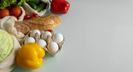 Vegetables, fruits, eggs in reusable eco cotton bags on table. Zero waste shopping concept. Plastic...