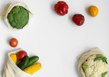 Vegetables in eco bag on white surface with a copy space. Pepper, tomato, corn, cucumber, broccoli,...