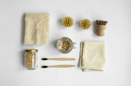 Zero waste kit. Set of eco friendly cleaning brushes, mesh cotton bags, glass jars with a nuts and bamboo toothbrushes. Natural and reusable items accessories on gray surface.の写真素材
