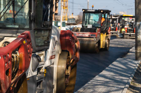 KYIV, UKRAINE - September 10, 2020: Heavy asphalt road roller with heavy vibration roller compactor that press new hot asphalt on the roadway on a road construction site on a street.のeditorial素材