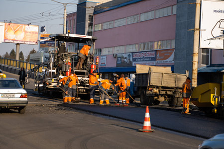 KYIV, UKRAINE - September 10, 2020: Industrial asphalt paver machine laying fresh asphalt on road...