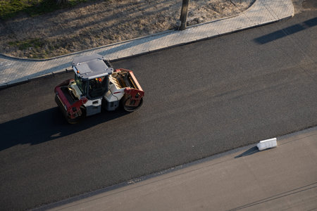 Asphalt road roller with heavy vibration roller compactor press new hot asphalt on the roadway on a...