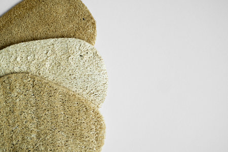Natural loofah kitchen dish washing sponges. Eco friendly dishwashing sponge on a gray surface, top...