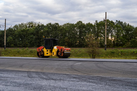 Asphalt road roller with heavy vibration roller compactor press new hot asphalt on the roadway on a...