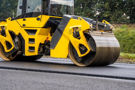 Asphalt road roller with heavy vibration roller compactor press new hot asphalt on the roadway on a...