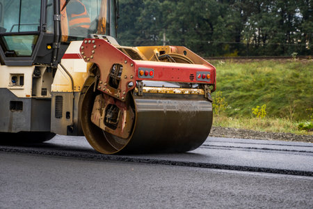 Asphalt road roller with heavy vibration roller compactor press new hot asphalt on the roadway on a...