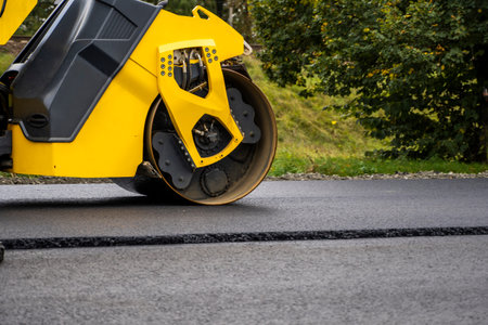 Asphalt road roller with heavy vibration roller compactor press new hot asphalt on the roadway on a...