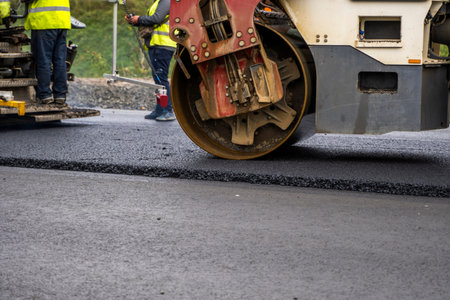 Asphalt road roller with heavy vibration roller compactor press new hot asphalt on the roadway on a...