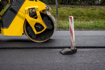 Asphalt road roller with heavy vibration roller compactor press new hot asphalt on the roadway on a...