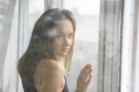 Portrait of young pensive caucasian brunette woman posing in black underwear and blue jeans,...