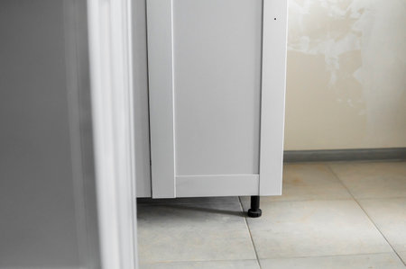 Lower custom kitchen cabinets installation with a furniture facades mdf. Gray modular kitchen from chipboard material on a various stages of installation. A frame furniture fronts mdf profile.の写真素材