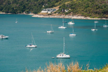 PHUKET, THAILAND - MAY 15, 2020: Sailing yachts and catamarans are parked at the harbor at Nai Harn Bay Phuket island.のeditorial素材