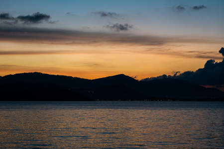 Sea view with sunset over the mountains.の写真素材